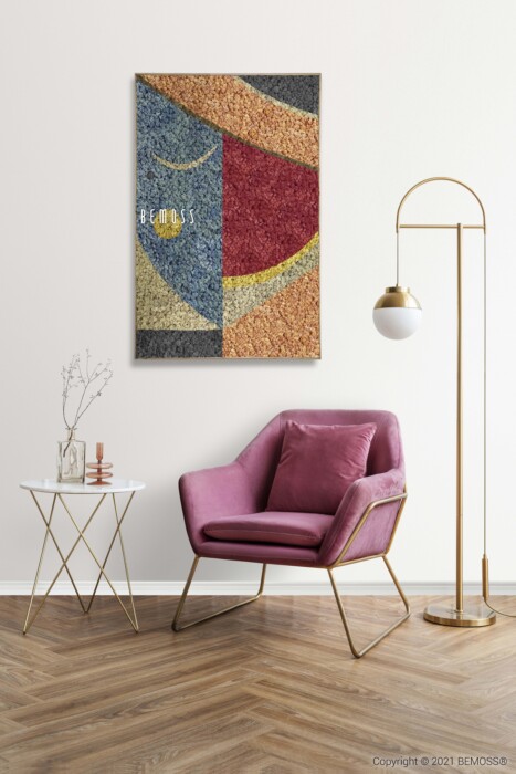 Une pièce au style moderne comprend un fauteuil en velours rose avec des pieds dorés, une table d'appoint blanche avec une base géométrique dorée et un lampadaire avec un pied doré et un abat-jour sphérique blanc. Un Machio abstrait est accroché au mur blanc orné de murs végétaux. Le sol est en bois.