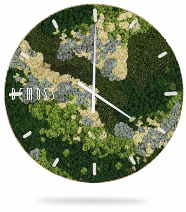 Une horloge murale ronde avec un fond composé de différentes nuances de mousse verte et beige, créant un motif de type camouflage. L'horloge a des aiguilles des heures et des minutes blanches et des index blancs. Le nom de la marque « Horloge de mousse BEMOSS® ORTHO SPRING avec cadran » s'affiche sur le côté gauche, offrant une touche d'élégance naturelle rappelant le design français des murs en mousse.