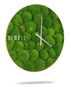 Une horloge murale ronde avec une texture de mousse verte unique comme arrière-plan. L'horloge a deux aiguilles blanches simples indiquant l'heure. "BEMOSS" est écrit en lettres blanches sur le côté gauche du visage. Cette Horloge de mousse BOLMOSS Minerva avec cadran semble flotter au-dessus d'un fond blanc.