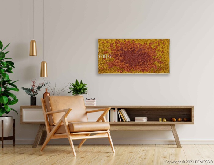 Un salon moderne comprenant un fauteuil en bois clair avec des coussins beiges, une console blanche à deux sections et divers objets de décoration. Au-dessus de la console, une œuvre d'art encadrée avec un motif abstrait texturé jaune-orange est accrochée à un mur de couleur claire orné de l'élégant Tableau de mousse BEMOSS® SPLASH Sienna.