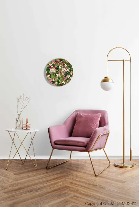 Un espace intérieur confortable comprenant un fauteuil rose avec un coussin moelleux, placé à côté d'une petite table ronde blanche aux fins pieds dorés. Sur la table se trouvent des branches décoratives dans un vase. Un lampadaire doré avec un abat-jour en forme de globe se trouve à proximité, contre les murs texturés BEMOSS. Un art mural floral se trouve au-dessus.