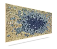 Une décoration murale rectangulaire de BEMOSS avec un motif texturé de mousse. La mousse est disposée en dégradés, passant du beige clair sur les bords au bleu profond au centre. Cet élégant tableau de mousse est encadré d'une fine bordure en bois.